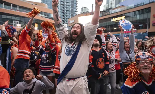 Edmonton Oilers fans celebrate as the Oilers defeated the Florida Panthers, as fans watched coverage of Game 5 of the NHL hockey Stanley Cup Final, Tuesday, June 18, 2024, in Edmonton, Alberta. (Jason Franson/The Canadian Press via AP)