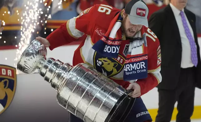 Florida Panthers center Aleksander Barkov hoists the Stanley Cup after the Panthers beat the Edmonton Oilers in Game 7 of the NHL hockey Stanley Cup Finals, Monday, June 24, 2024, in Sunrise, Fla. (AP Photo/Wilfredo Lee)