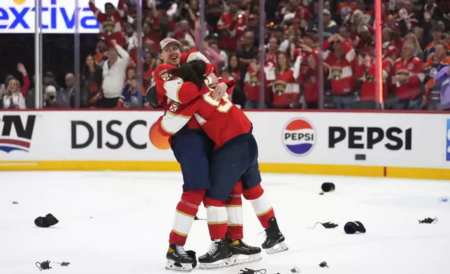 Florida Panthers defenseman Niko Mikkola, left, and left wing Ryan Lomberg, right, hug after winning the NHL hockey Stanley Cup Final against the Edmonton Oilers, Monday, June 24, 2024, in Sunrise, Fla. (AP Photo/Wilfredo Lee)