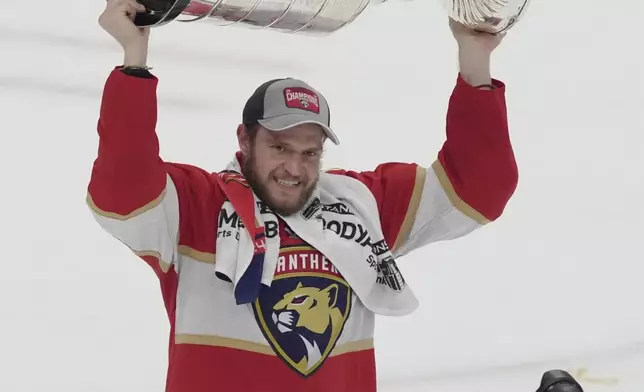 Florida Panthers team captain Aleksander Barkov (16) raises the Stanley Cup trophy after defeating the Edmonton Oilers in Game 7 of the NHL hockey Stanley Cup Final, Monday, June 24, 2024, in Sunrise, Fla. The Panthers defeated the Oilers 2-1. (AP Photo/Rebecca Blackwell)