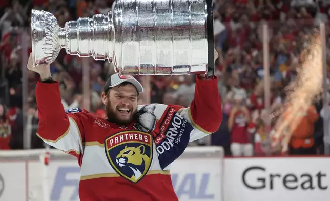 Florida Panthers center Aleksander Barkov hoists the Stanley Cup after the Panthers beat the Edmonton Oilers in Game 7 of the NHL hockey Stanley Cup Finals, Monday, June 24, 2024, in Sunrise, Fla. (AP Photo/Wilfredo Lee)