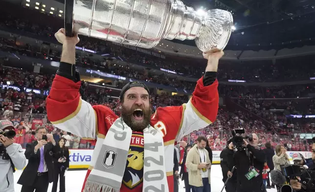 Florida Panthers center Aleksander Barkov lifts the Stanley Cup trophy after Game 7 of the NHL hockey Stanley Cup Final against the Edmonton Oilers, Monday, June 24, 2024, in Sunrise, Fla. The Panthers defeated the Oilers 2-1. (AP Photo/Wilfredo Lee)