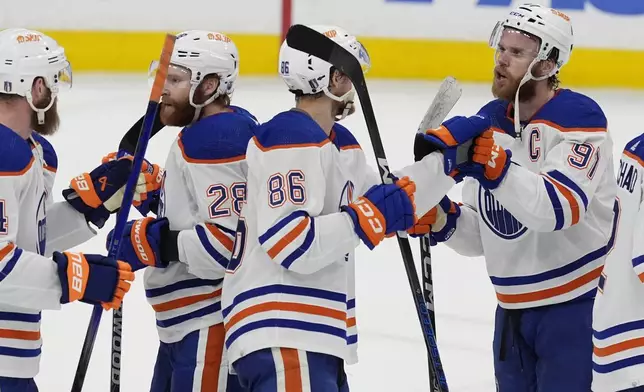 Edmonton Oilers players celebrate at the end of Game 5 of the NHL hockey Stanley Cup Finals against the Florida Panthers, Tuesday, June 18, 2024, in Sunrise, Fla. The Oilers defeated the Panthers 5-3. (AP Photo/Rebecca Blackwell)
