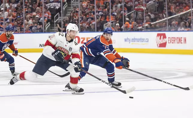 Florida Panthers' Gustav Forsling (42) is chased by Edmonton Oilers' Ryan McLeod (71) dduring the second period of Game 6 of the NHL hockey Stanley Cup Final, Friday, June 21, 2024, in Edmonton, Alberta. (Jason Franson/The Canadian Press via AP)