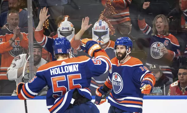 Edmonton Oilers' Dylan Holloway (55) and Adam Henrique (19) celebrate a goal against the Florida Panthers during the second period of Game 6 of the NHL hockey Stanley Cup Final, Friday, June 21, 2024, in Edmonton, Alberta. (Jason Franson/The Canadian Press via AP)