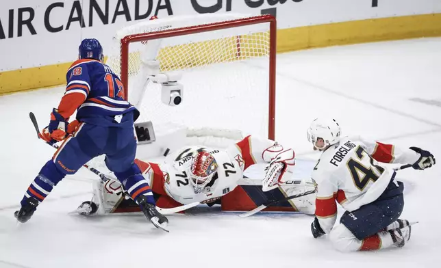 Florida Panthers goalie Sergei Bobrovsky (72) is scored on by Edmonton Oilers' Zach Hyman (18) as Gustav Forsling (42) watches during the second period of Game 6 of the NHL hockey Stanley Cup Final, Friday, June 21, 2024, in Edmonton, Alberta. (Jeff McIntosh/The Canadian Press via AP)
