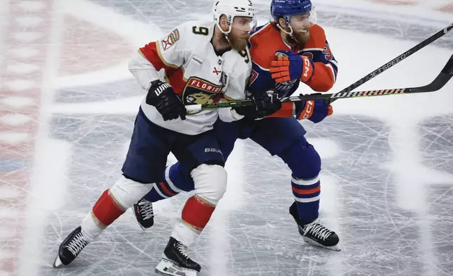 Florida Panthers' Sam Bennett (9) checks Edmonton Oilers' Connor McDavid (97) during the second period of Game 6 of the NHL hockey Stanley Cup Final, Friday, June 21, 2024, in Edmonton, Alberta. (Jeff McIntosh/The Canadian Press via AP)
