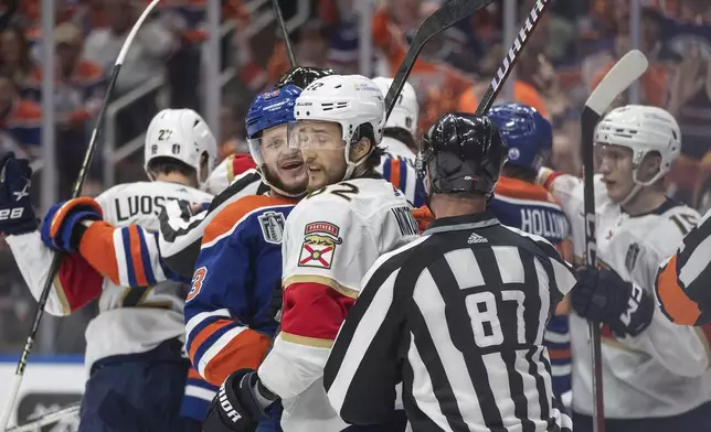 Florida Panthers' Brandon Montour (62) and Edmonton Oilers' Mattias Janmark (13) rough it up during the second period of Game 6 of the NHL hockey Stanley Cup Final, Friday, June 21, 2024, in Edmonton, Alberta. (Jason Franson/The Canadian Press via AP)