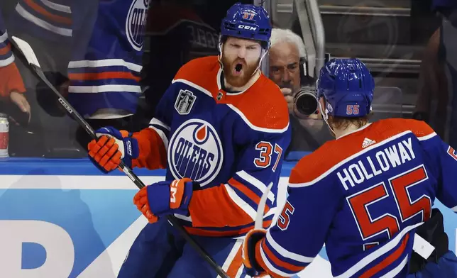 Edmonton Oilers' Warren Foegele (37) celebrates his goal against the Florida Panthers with Dylan Holloway (55) during the first period of Game 6 of the NHL hockey Stanley Cup Final, Friday, June 21, 2024, in Edmonton, Alberta. (Jeff McIntosh/The Canadian Press via AP)