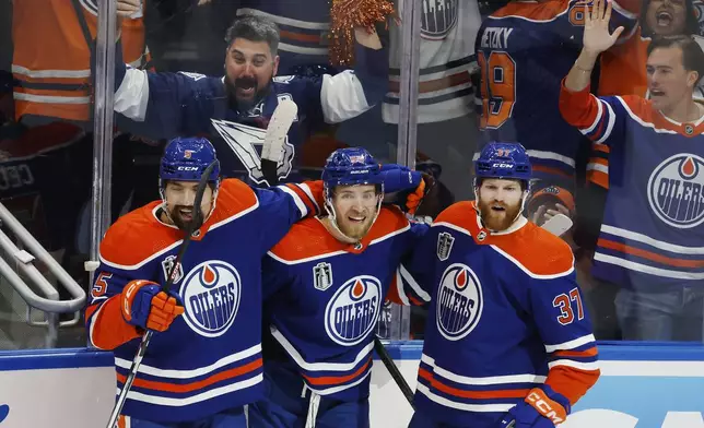 Edmonton Oilers' Warren Foegele (37) celebrates his goal against the Florida Panthers with Cody Ceci (5) and Dylan Holloway (55) during the first period of Game 6 of the NHL hockey Stanley Cup Final, Friday, June 21, 2024, in Edmonton, Alberta. (Jeff McIntosh/The Canadian Press via AP)