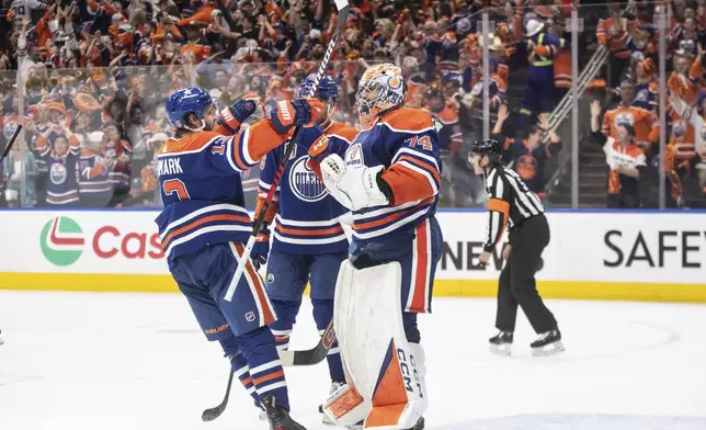 Edmonton Oilers' Mattias Janmark (13) and goalie Stuart Skinner (74) celebrate a goal against the Florida Panthers during the third period of Game 6 of the NHL hockey Stanley Cup Final, Friday, June 21, 2024, in Edmonton, Alberta. The Oilers won 5-1 to tie the series. (Jason Franson/The Canadian Press via AP)