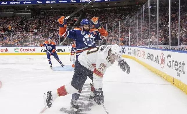 Florida Panthers' Vladimir Tarasenko (10) is checked by Edmonton Oilers' Darnell Nurse (25) during the third period of Game 6 of the NHL hockey Stanley Cup Final, Friday, June 21, 2024, in Edmonton, Alberta. The Oilers won 5-1 to tie the series. (Jason Franson/The Canadian Press via AP)