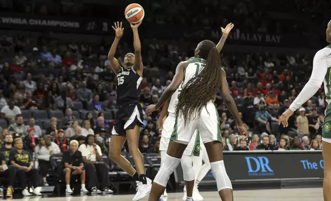 Las Vegas Aces guard Tiffany Hayes (15) shoots over Seattle Storm center Ezi Magbegor (13) during the first half of a WNBA basketball game Wednesday, June 19, 2024, in Las Vegas. (Steve Marcus/Las Vegas Sun via AP)