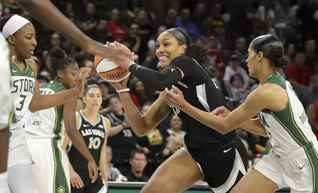 Las Vegas Aces center A'ja Wilson (22) drives between Seattle Storm forward Nneka Ogwumike (3) and guard Skylar Diggins-Smith during the first half of a WNBA basketball game Wednesday, June 19, 2024, in Las Vegas. (Steve Marcus/Las Vegas Sun via AP)
