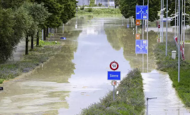 The Rhone River is overflowing streets following the storms that caused major flooding, in Sierre, Switzerland, Sunday, June 30, 2024. (Jean-Christophe Bott/Keystone via AP)