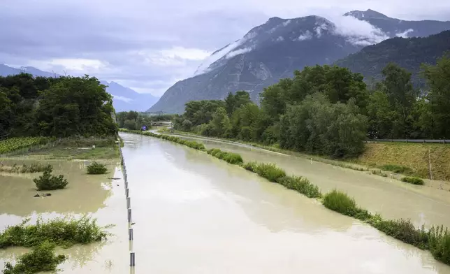 The Rhone River is overflowing the A9 motorway following the storms that caused major flooding, in Sierre, Switzerland, Sunday, June 30, 2024. (Jean-Christophe Bott/Keystone via AP)