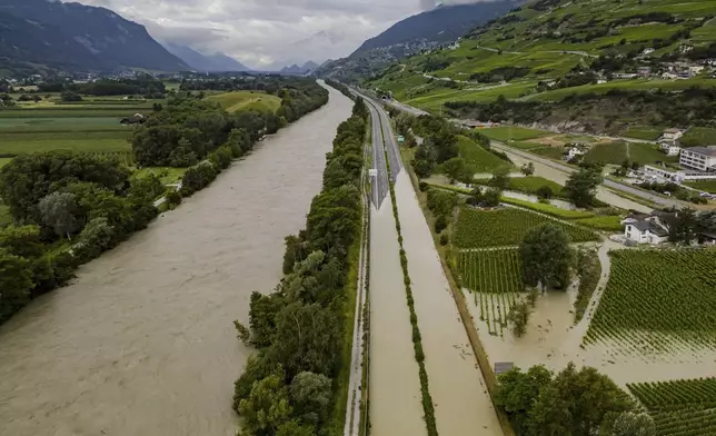 The Rhone River is overflowing the A9 motorway following the storms that caused major flooding, in Sierre, Switzerland, Sunday, June 30, 2024. (Jean-Christophe Bott/Keystone via AP)