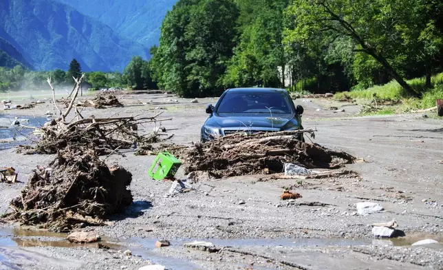 A car is stuck in the mud at the Sorte village, community of Lostallo, Southern Switzerland, after a landslide, caused by the bad weather and heavy rain in the Misox valley, in Lostallo, Southern Switzerland, Saturday, June 22 2024. Massive thunderstorms and rainfall led to a flooding situation on Friday evening after a landslide in the Misox valley. Four people went missing on Saturday morning. Several dozen people had to be evacuated from their homes in the Misox and Calanca regions. (Samuel Golay/Keystone via AP)