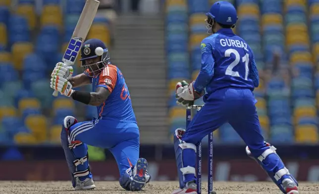 India's Suryakumar Yadav, left, plays a shot during the ICC Men's T20 World Cup cricket match between Afghanistan and India at Kensington Oval in Bridgetown, Barbados, Thursday, June 20, 2024. (AP Photo/Ricardo Mazalan)