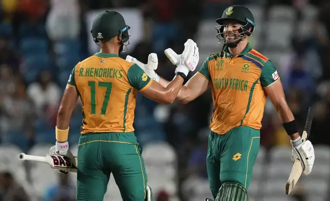 South Africa's Reeza Hendricks, left, and teammate Aiden Markram celebrate after defeating Afghanistan in their men's T20 World Cup semifinal cricket match at the Brian Lara Cricket Academy in Tarouba, Trinidad and Tabago, Wednesday, June 26, 2024. (AP Photo/Ricardo Mazalan)