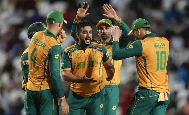 South Africa's Tabraiz Shamsi, centre, is congratulated by teammates after dismissing Afghanistan's Noor Ahmad during the men's T20 World Cup semifinal cricket match between Afghanistan and South Africa at the Brian Lara Cricket Academy in Tarouba, Trinidad and Tabago, Wednesday, June 26, 2024. (AP Photo/Ricardo Mazalan)