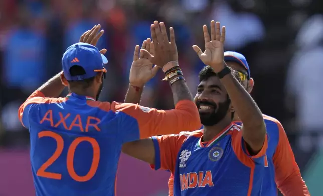 India's Jasprit Bumrah, right, celebrates with teammate Axar Patel after the dismissal of England's Phil Salt during the ICC Men's T20 World Cup second semifinal cricket match between England and India at the Guyana National Stadium in Providence, Guyana, Thursday, June 27, 2024. (AP Photo/Ramon Espinosa)