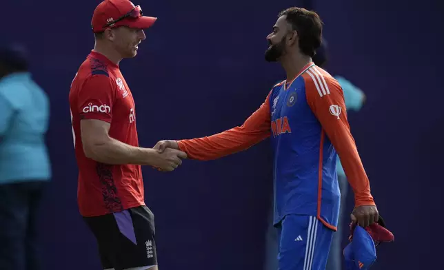 India's Virat Kohli, right, shake hands with England's captain Jos Buttler at the end of the ICC Men's T20 World Cup second semifinal cricket match between England and India at the Guyana National Stadium in Providence, Guyana, Thursday, June 27, 2024. (AP Photo/Ramon Espinosa)