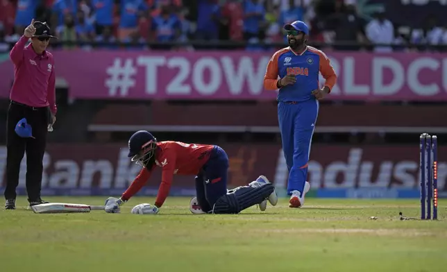 India's captain Rohit Sharma, right, celebrates the run-out of England's Adil Rashid, on ground, during the ICC Men's T20 World Cup second semifinal cricket match between England and India at the Guyana National Stadium in Providence, Guyana, Thursday, June 27, 2024. (AP Photo/Ramon Espinosa)