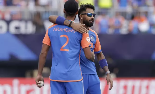 India's Arshdeep Singh, left, celebrates with teammate Hardik Pandya after the dismissal of Pakistan's Imad Wasim during the ICC Men's T20 World Cup cricket match between India and Pakistan at the Nassau County International Cricket Stadium in Westbury, New York, Sunday, June 9, 2024. (AP Photo/Adam Hunger)