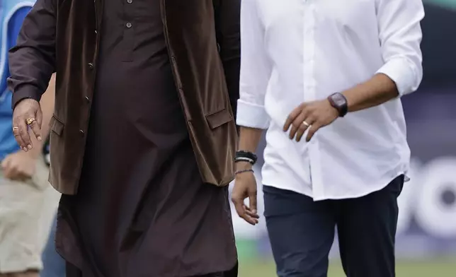 Former cricketers Navjot Singh Sidhu of India, left, and Wasim Akram of Pakistan walk in the ground ahead of the ICC Men's T20 World Cup cricket match between India and Pakistan at the Nassau County International Cricket Stadium in Westbury, New York, Sunday, June 9, 2024. (AP Photo/Adam Hunger)