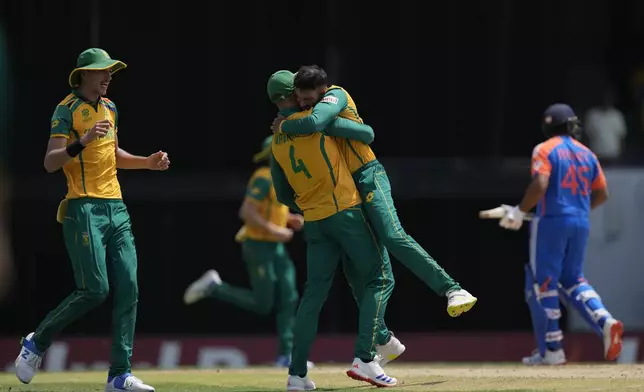 South Africa's Keshav Maharaj, second right, celebrates with teammates after the dismissal of India's captain Rohit Sharma, right, during the ICC Men's T20 World Cup final cricket match between India and South Africa at Kensington Oval in Bridgetown, Barbados, Saturday, June 29, 2024. (AP Photo/Ricardo Mazalan)