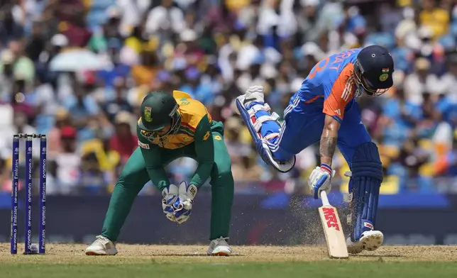 India's Virat Kohli, right, makes his crease as South Africa's Quinton de Kock fields the ball during the ICC Men's T20 World Cup final cricket match between India and South Africa at Kensington Oval in Bridgetown, Barbados, Saturday, June 29, 2024. (AP Photo/Ramon Espinosa)