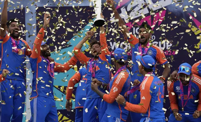 Indian players celebrate with the winners trophy after defeating South Africa in the ICC Men's T20 World Cup final cricket match at Kensington Oval in Bridgetown, Barbados, Saturday, June 29, 2024. (AP Photo/Ricardo Mazalan)