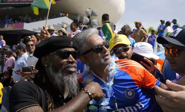 A fan takes a selfie with West Indies' cricket legend Chris Gayle before the ICC Men's T20 World Cup final cricket match between India and South Africa at Kensington Oval in Bridgetown, Barbados, Saturday, June 29, 2024. (AP Photo/Ramon Espinosa)