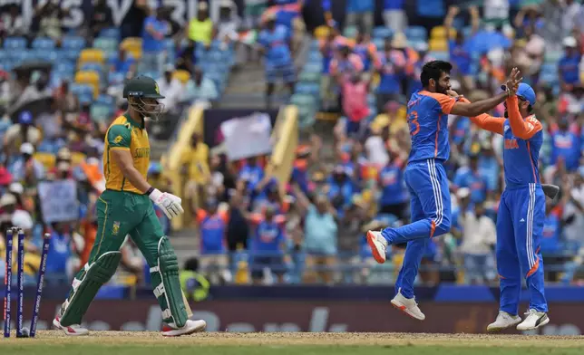 South Africa's Reeza Hendricks, left, is bowled out by India's Jasprit Bumrah, centre, during the ICC Men's T20 World Cup final cricket match between India and South Africa at Kensington Oval in Bridgetown, Barbados, Saturday, June 29, 2024. (AP Photo/Ramon Espinosa)