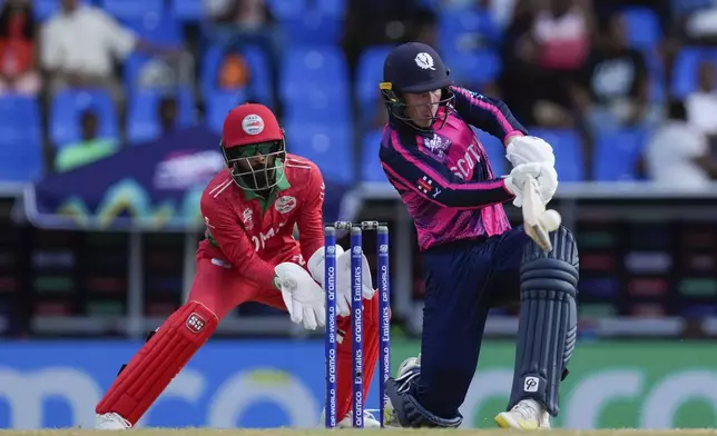 Scotland's Brandon McMullen plays a shot as Oman wicket keeper Pratik Athavale looks on during an ICC Men's T20 World Cup cricket match at Sir Vivian Richards Stadium in North Sound, Antigua and Barbuda, Sunday, June 9, 2024. (AP Photo/Ricardo Mazalan)