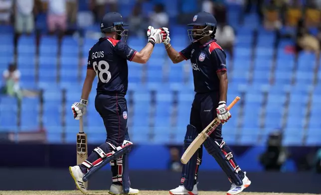 United States' Andries Gous, left, and batting partner Harmeet Singh celebrate scoring runs during the ICC Men's T20 World Cup cricket match between the United States and South Africa at Sir Vivian Richards Stadium in North Sound, Antigua and Barbuda, Wednesday, June 19, 2024. (AP Photo/Ricardo Mazalan)