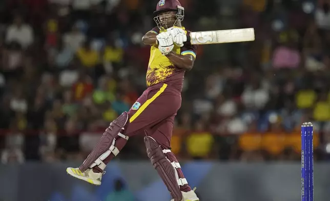 West Indies' Johnson Charles hits a boundary against Afghanistan during an ICC Men's T20 World Cup cricket match at Daren Sammy National Cricket Stadium in Gros Islet, Saint Lucia, Monday, June 17, 2024. (AP Photo/Ramon Espinosa)
