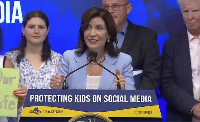 In this still image taken from video of the Office of the New York Governor, New York Gov. Kathy Hochul speaks during a bill signing, in New York, Thursday, June 20, 2024. Hochul signed a bill on Thursday that would allow parents to block their children from getting social media posts suggested by a platform's algorithm, a move to limit feeds critics argue are addictive. (Office of the New York Governor via AP)