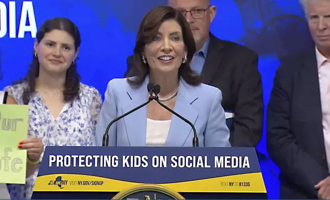 In this still image taken from video of the Office of the New York Governor, New York Gov. Kathy Hochul speaks during a bill signing, in New York, Thursday, June 20, 2024. Hochul signed a bill on Thursday that would allow parents to block their children from getting social media posts suggested by a platform's algorithm, a move to limit feeds critics argue are addictive. (Office of the New York Governor via AP)