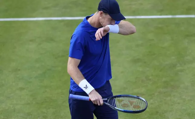 FILE - Andy Murray of Britain wipes his face as he is injured during his men's singles match on day five of The Queen's Club tennis tournament, in London, Wednesday, June 19, 2024. Two-time Wimbledon champion Andy Murray still had not decided as of Thursday whether he will be able to compete at the grass-court Grand Slam tournament that begins next week and he is likelier to enter doubles than singles if he can play at all after recent surgery to remove a cyst on his spinal cord. (AP Photo/Kirsty Wigglesworth, File)