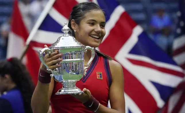 FILE - Emma Raducanu, of Britain, holds up the US Open championship trophy after defeating Leylah Fernandez, of Canada, during the women's singles final of the US Open tennis championships, Saturday, Sept. 11, 2021, in New York. Raducanu will be back on Centre Court at Wimbledon when the Grand Slam starts Monday, July 1, 2024. She faces the No. 22 seed Ekaterina Alexandrova a year after she missed the grass-court major while recovering from ankle and wrist surgeries. (AP Photo/Elise Amendola, File)