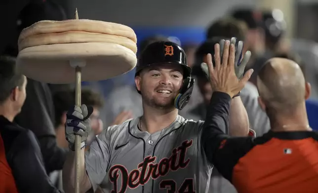 Detroit Tigers' Jake Rogers (34) high-fives a teammate in the dugout after hitting a home run against the Los Angeles Angels during the sixth inning of a baseball game in Anaheim, Calif., Saturday, June 29, 2024. (AP Photo/Eric Thayer)