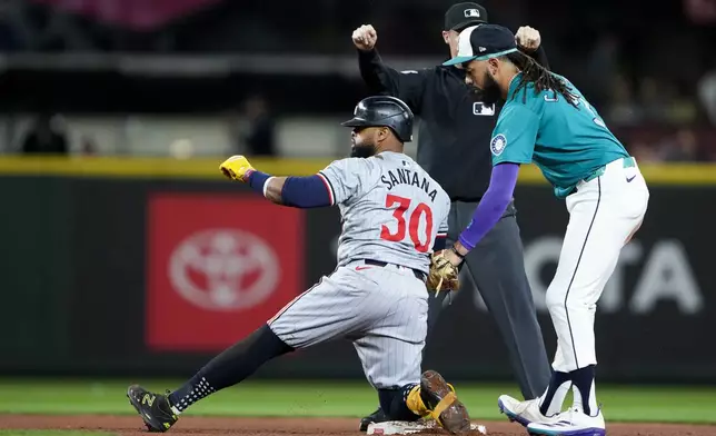 Minnesota Twins' Carlos Santana (30) is called safe at second for a double in front of the tag from Seattle Mariners shortstop J.P. Crawford, right, during the fourth inning of a baseball game Saturday, June 29, 2024, in Seattle. (AP Photo/Lindsey Wasson)
