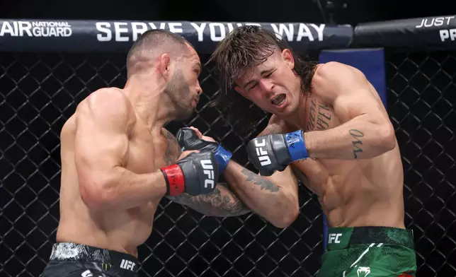 Dan Ige, left, punches Diego Lopes during a 165-pound catchweight mixed martial arts bout at UFC 303, Saturday, June 29, 2024, in Las Vegas. Ige replaced Brian Ortega, who withdrew from the bout due to illness. (Steve Marcus/Las Vegas Sun via AP)