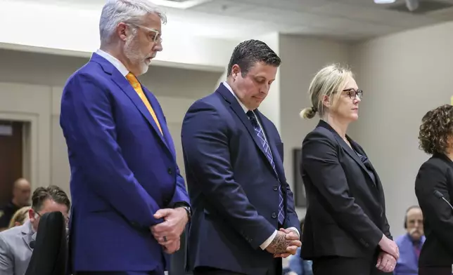 Jeffrey Nelson, flanked by attorneys, stands at the King County Maleng Regional Justice Center in Kent, Wash., on Thursday, June 27, 2024. A jury found the suburban Seattle police officer guilty of murder in the 2019 shooting death of a homeless man outside a convenience store, marking the first conviction under a Washington state law easing prosecution of law enforcement officers for on-duty killings. (Kevin Clark/The Seattle Times via AP)
