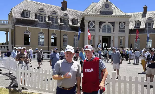 Frank Bensel, left, and his caddie and 14-year-old son, Hagen, pose in front of the clubhouse after Bensel turned up a pair of aces on the back-to-back holes during the second round of the U.S. Senior Open golf tournament in Newport, R.I., Friday, June 28, 2024. (AP Photo/Jimmy Golen)