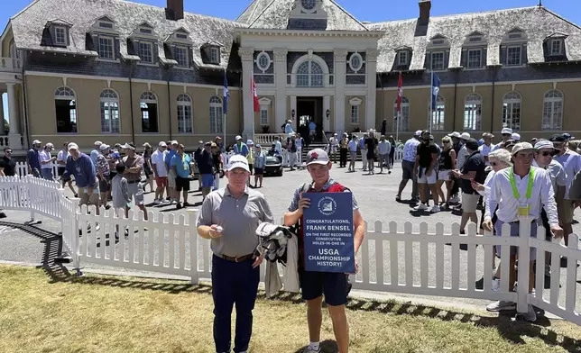 Frank Bensel, left, and his caddie and 14-year-old son, Hagen, pose in front of the clubhouse after Bensel turned up a pair of aces on the back-to-back holes during the second round of the U.S. Senior Open golf tournament at the Newport Country Club in Newport, R.I., Friday, June 28, 2024. (AP Photo/Jimmy Golen)