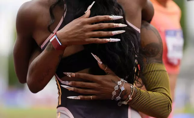 Gabby Thomas gets a hug from Sha'Carri Richardson after winning the women's 200-meter final during the U.S. Track and Field Olympic Team Trials Saturday, June 29, 2024, in Eugene, Ore. (AP Photo/Charlie Neibergall)