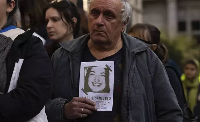A man holds an image of Amelia Sanjurjo during her funeral service held at the University of the Republic in Montevideo, Uruguay, Thursday, June 6, 2024. The Uruguayan Prosecutor’s Office confirmed that the human remains found in June 2023 at the 14th Battalion of the Uruguayan Army belong to Sanjurjo, a victim of the 1973-1985 dictatorship who was 41 years old and pregnant at the time of her disappearance. (AP Photo/Matilde Campodonico)